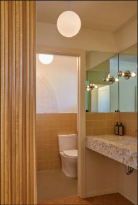 bagno con servizi igienici e grande specchio di The Capri Hotel a Ojai
