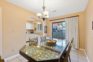 a dining room and kitchen with a glass table and chairs at Peach Seashell in Destin
