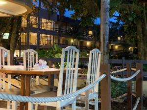 a wooden table and chairs with a building in the background at Riviera Flat 120 - Com serviços de hotelaria in Riviera de São Lourenço