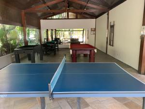 a blue ping pong table in a room with tables at Riviera Flat 120 - Com serviços de hotelaria in Riviera de São Lourenço