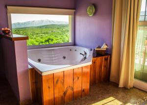 baño con bañera y ventana grande en Monte Adentro en Capilla del Monte