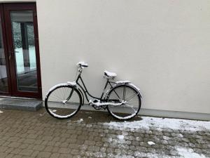 a bike parked next to a building with snow on it at Mäekalda Guesthouse Garden Villa with private sauna in Rakvere
