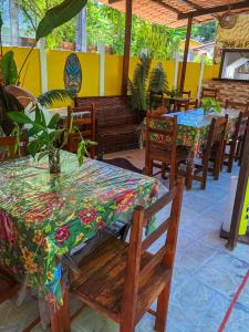 a restaurant with tables and chairs with a colorful table cloth at Pousada Vila do Sossego in Morro de São Paulo