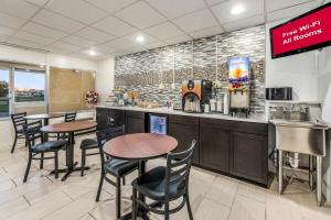 a restaurant with tables and chairs and a counter at Red Roof Inn & Suites Wapakoneta in Wapakoneta