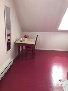 a dining room with a table and a red floor at Maison de campagne le Nichouette in Les Éboulements