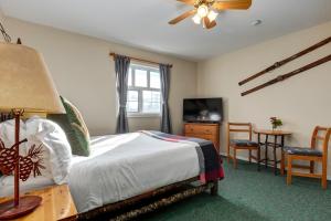 レベルストークにあるCourthouse Inn Revelstokeのベッドルーム(ベッド1台、テーブル、テレビ付)