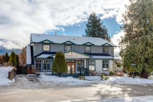 ein großes Haus mit Schnee auf dem Boden in der Unterkunft Courthouse Inn Revelstoke in Revelstoke