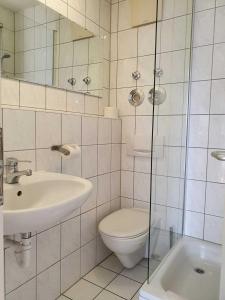 een witte badkamer met een toilet en een wastafel bij CityPark Aparthotel in Keulen