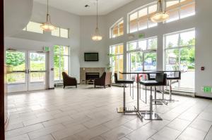 - un hall avec une table, des chaises et une cheminée dans l'établissement Red Lion Inn & Suites Des Moines, à Des Moines