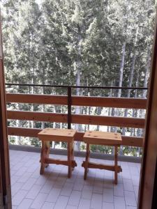 a bench on a balcony with a view of trees at Abetone - Parco dei Daini in Abetone +3 photos