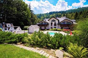 a house with a swimming pool in a yard at Górska Legenda Apartamenty & Domki in Szczyrk