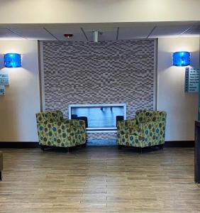 two chairs in a waiting room with a brick wall at Holiday Inn Express Fresno River Park Highway 41, an IHG Hotel in Fresno