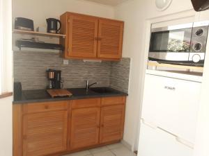 a kitchen with a sink and a refrigerator at PARADIS TURQUOISE LOCATIONS in Les Trois-Îlets