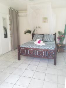 a bed sitting in a room with a white tile floor at PARADIS TURQUOISE LOCATIONS in Les Trois-Îlets