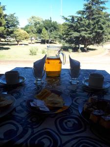 a table with food and a pitcher of orange juice at Hotel Silver Golf in Sierra de la Ventana