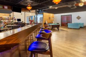 a bar with a row of stools in a room at Starved Rock Motor Inn Travelodge by Wyndham in Streator