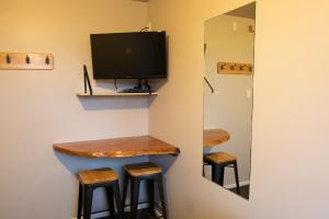 un bar en una habitación con 2 taburetes y TV en Dusky Lodge en Kaikoura