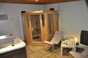 cocina con silla y armario de madera en La maison du Bonheur "LE GITE" en Saint-Ouen-sous-Bailly