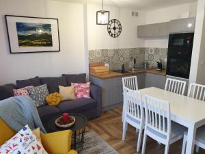 a living room with a couch and a table at Apartament Gaia in Kościelisko