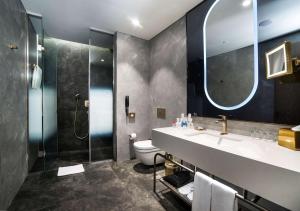 a bathroom with a sink and a shower and a toilet at Radisson Collection Hotel, Vadistanbul in Istanbul