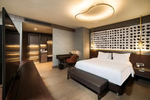 a bedroom with a white bed and a desk and a room at Radisson Collection Hotel, Vadistanbul in Istanbul