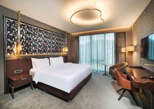 a hotel room with a bed and a desk at Radisson Collection Hotel, Vadistanbul in Istanbul