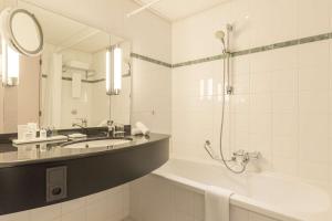 
a bathroom with a sink, mirror, and bathtub at Radisson Blu Hotel Amsterdam Airport, Schiphol in Schiphol
