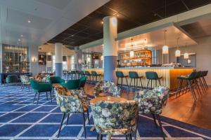 a dining room with chairs and a bar at Radisson Blu Hotel Amsterdam Airport, Schiphol in Schiphol