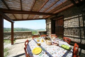 a table on a patio with a view of the mountains at Agriturismo Monte Valentino in Pietralunga