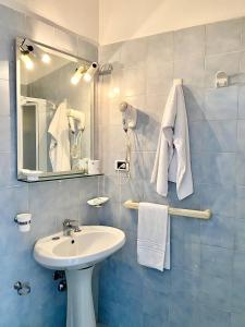 a bathroom with a sink and a mirror and towels at Il Romito in Quercianella