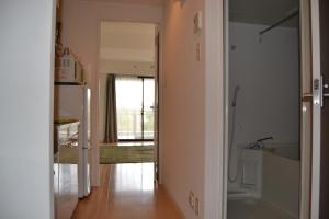 Zimmer mit einem Flur, einem Kühlschrank und einer Küche in der Unterkunft Gracias in Kagoshima