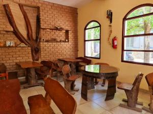 Cafayate los toneles في كفايات: غرفة بها طاولات وكراسي خشبية ونوافذ