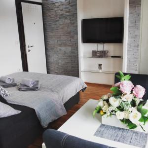 a bedroom with a bed and flowers on a table at Apartments Novakovic in Zlatibor