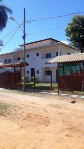 a white building with a fence in front of it at Pousada Tio Loco in Serra do Cipo