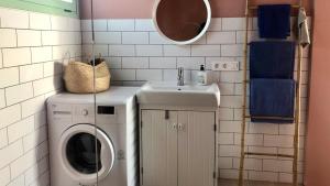 a bathroom with a washing machine and a sink at CASA ANCLADA en LA SANTA- 4 Apartamentos frente al mar- 1ª linea solarium in La Santa