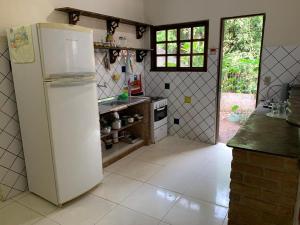 eine Küche mit einem weißen Kühlschrank und einem Herd in der Unterkunft Casa Grande equipada para quatro pessoas in Lençóis