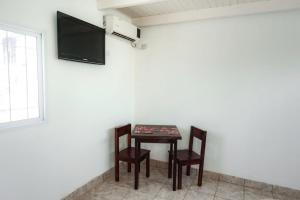 Habitación con mesa, 2 sillas y TV de pantalla plana. en Cabañas Villa del Sol en Salta