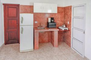a kitchen with a white refrigerator and a sink at Cabañas Villa del Sol in Salta