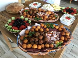 einen Tisch mit vielen verschiedenen Arten von Lebensmitteln in der Unterkunft Pensiunea Agroturistica Cerna, Vaideeni, Valcea in Vaideeni