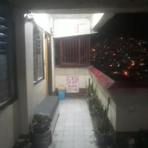 uma vista para uma varanda à noite com uma janela em CVBNB BAGUIO GUESTHOUSE em Baguio