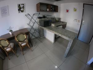 a kitchen with a counter and a table and chairs at Imperial Flat in João Pessoa