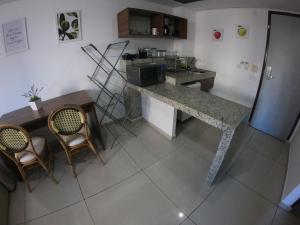 een keuken met een aanrecht, een tafel en stoelen bij Imperial Flat in João Pessoa