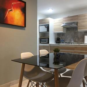 a kitchen with a dining table and white chairs at Blue Dreams Apartament Del Valle in Mexico City