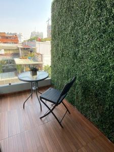 a table and a chair sitting on a balcony at Blue Dreams Apartament Del Valle in Mexico City