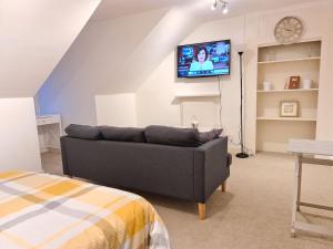 a living room with a couch and a flat screen tv at Grace Apartments - Living Spring 1 in Ashford
