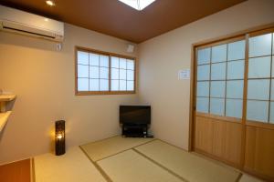 a living room with a door and a television at Rokuhara Inn in Kyoto