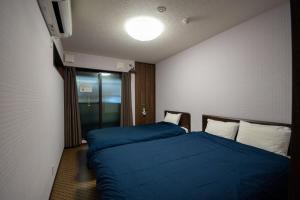 a hotel room with two beds and a television at Rokuhara Inn in Kyoto