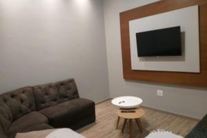 uma sala de estar com um sofá e uma televisão em RESIDENCIA CIDADE VERDE 7 em Maringá