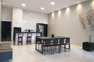 a kitchen with a table and chairs and a counter at RESIDENCIA CIDADE VERDE 7 in Maringá