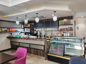 a fast food restaurant with a counter and purple chairs at Meriton Inn in Kuantan